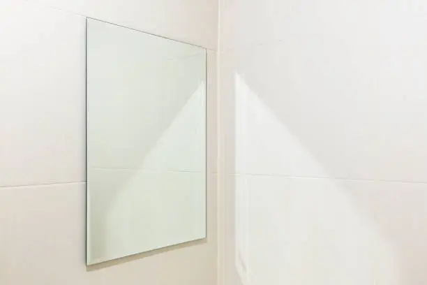 Mirror and white tile wall in bathroom.