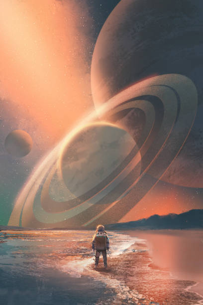 astronaut stehen am strand, blick auf planeten - saturn planet stock-grafiken, -clipart, -cartoons und -symbole