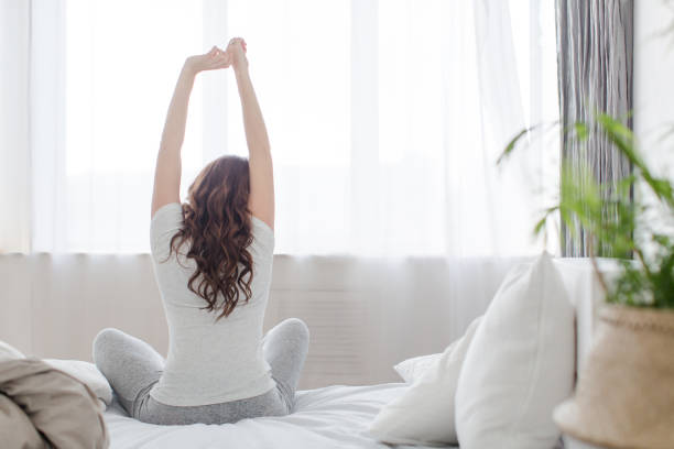 istock Female stretching sitting on bed in morning 648314640