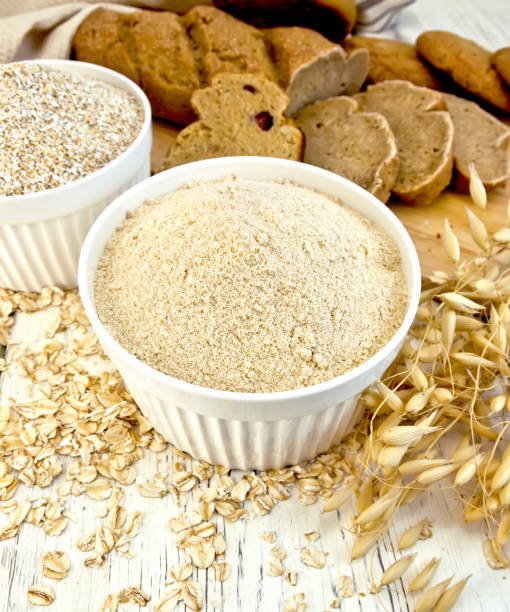 istock Flour oat and bran in white bowl with bread on board 648315096