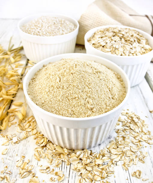 istock Flour oat in white bowls with bran and flakes on board 648315114