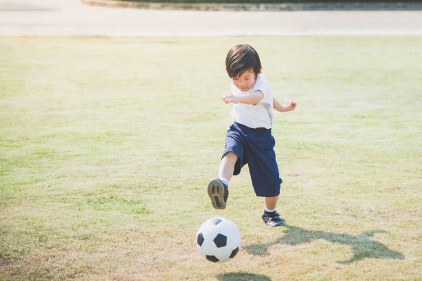 istock boy kicking football 648315342