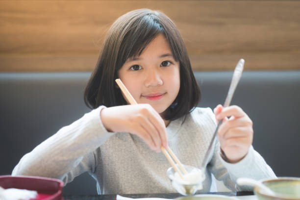 Asian girl eating sukiyaki