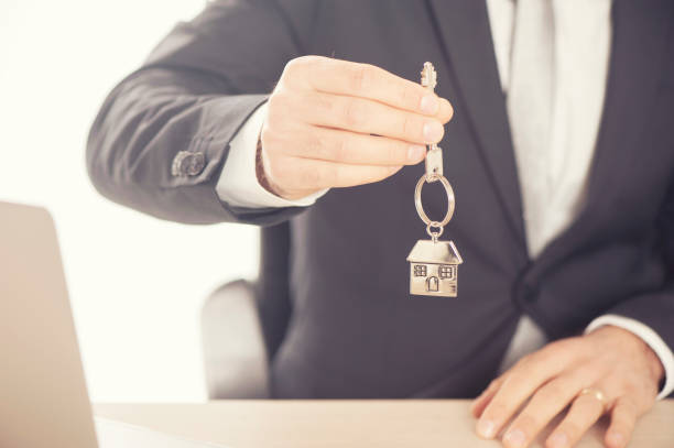istock Estate agent giving house keys 648323240