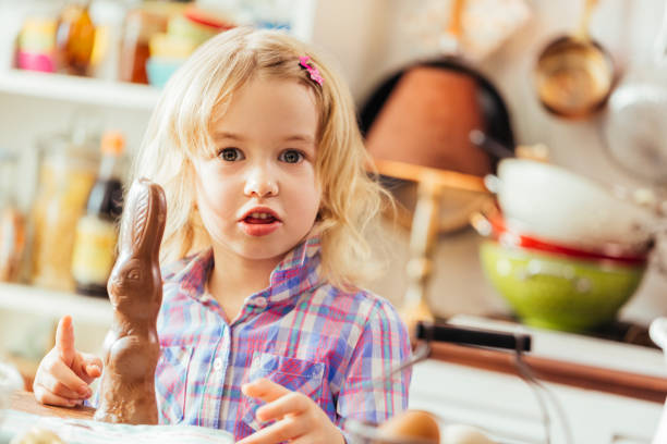 istock Little Girl Eating Chocolate Easter Bunny 648348750