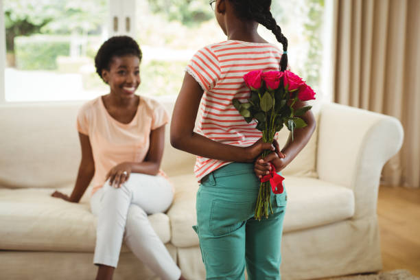 istock Daughter hiding flowers behind her back for mother 648348866