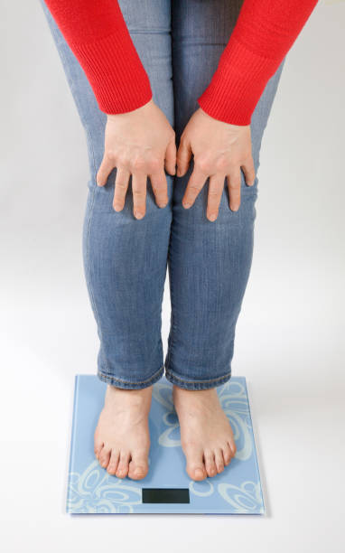 woman standing on the scales stock photo