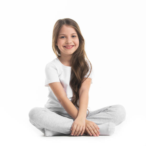 Girl sitting turkish Portrait of small girl sitting turkish isolated on white background smiling kids on white stock pictures, royalty-free photos & images