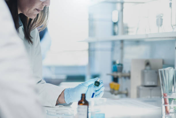 istock Scientist Placing a Reagent into a Petri Dish 648369108