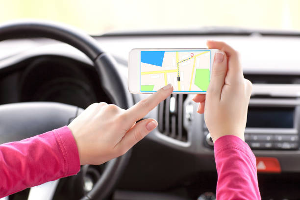 istock female driver hand holding a phone with interface navigator on a screen 648374398