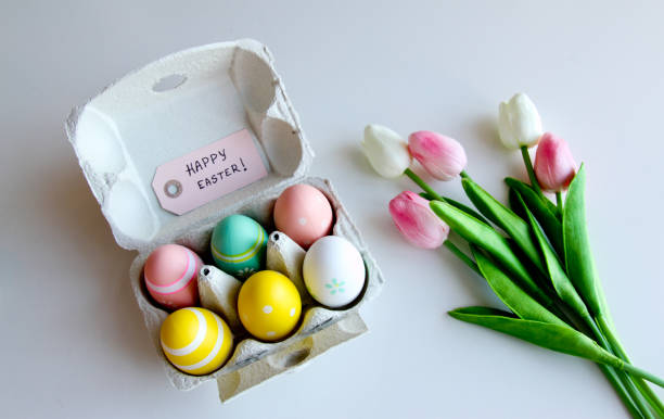 A bouquet of tulips with Easter eggs on a white background stock photo