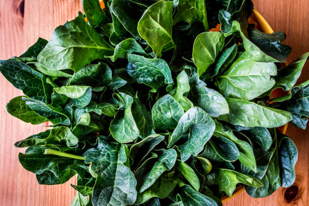 istock Fresh Green Spinach Leaves on wooden surface. 648393480