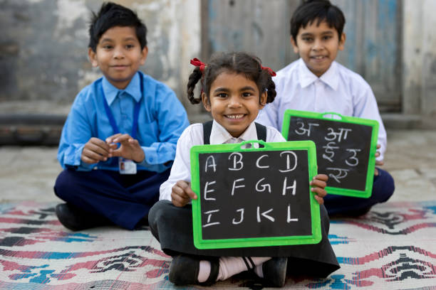istock Little school children in uniform holding slate 648396594