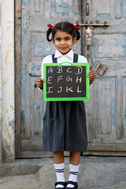 istock Little school girl holding slate 648396804