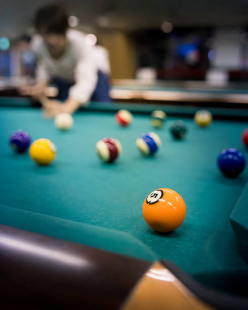istock Young woman playing billiards 648397434