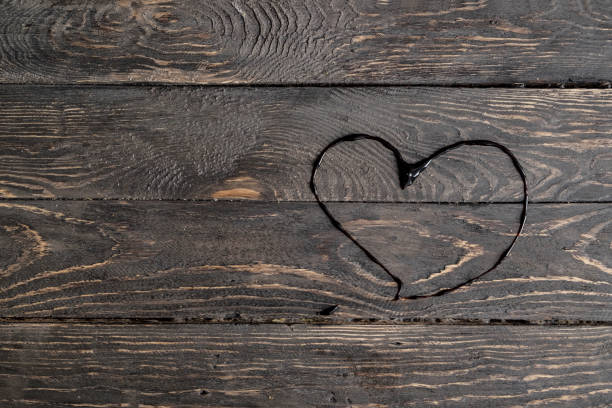 istock Heart on a dark wooden rough background 648397622
