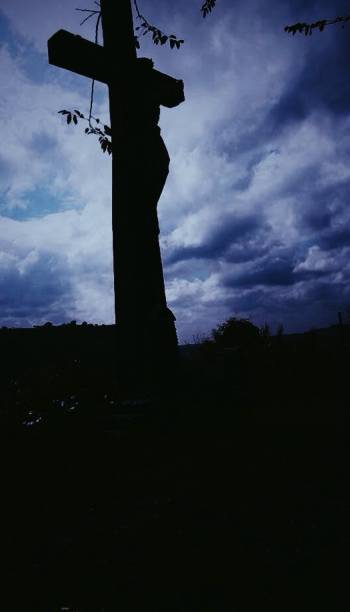 Jesus Christ crucified in the cross located in the mountain with clouds A figure of jesus Christ standing at the summit of a mountain in tarlac Philippines with a cumolonimbus clouds in it. -photo taken in tarlac philippines what mountain was jesus crucified on stock pictures, royalty-free photos & images