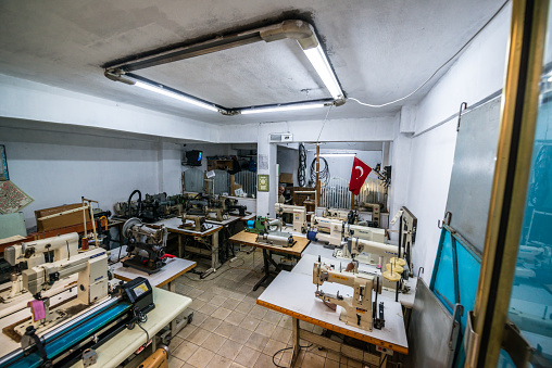 Istanbul, Turkey - October 27, 2014: Small atelier in Fatih district, viewed from the street. Senior man working alone is visible inside the atelier.