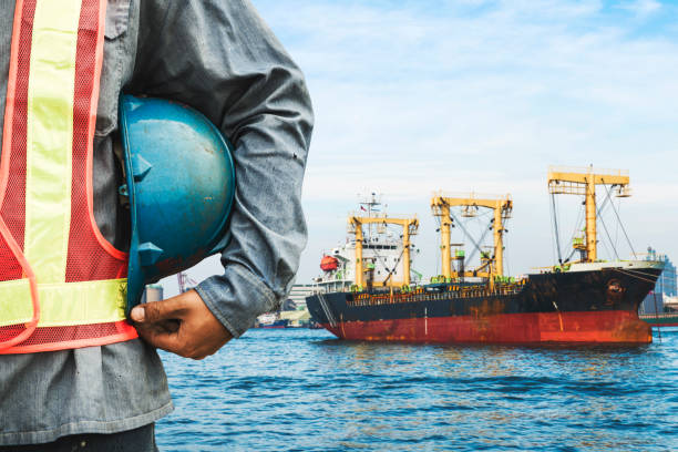 istock Harbor dock worker talking on radio with ship background 648412312