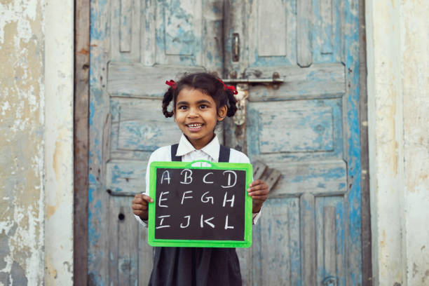 istock Little school girl holding slate 648415844