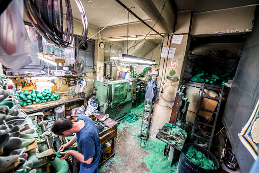 Istanbul, Turkey - October 27, 2014: Shoe manufacturing in Fatih district. Man working inside, shot from the street.