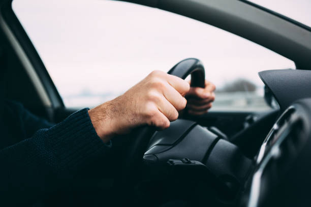 istock Close-up of a man's hands driving a car 648433564