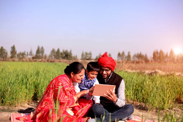 istock Cheerful Family using I pad in the green field 648434146