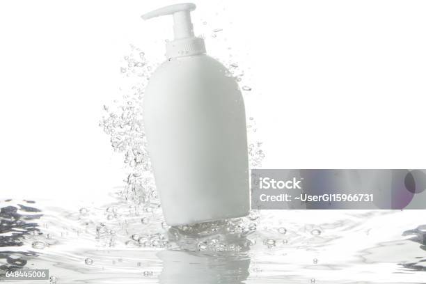 Liquid Soap Dispenser And Bubbles Over Rippled Water Stock Photo - Download Image Now