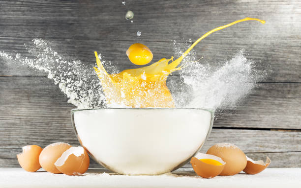 istock egg yolk falling into a bowl of flour 648445108