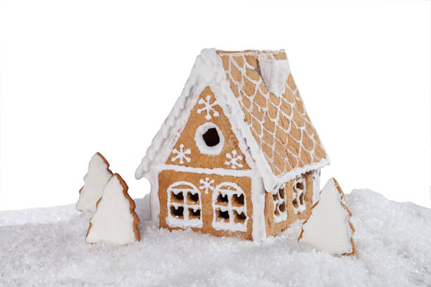 istock gingerbread house in the snow isolated on white background. 648452538