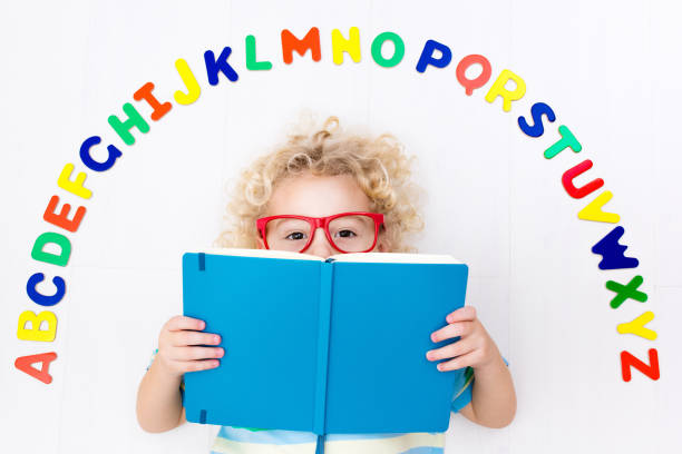 istock Child learning letters of alphabet and reading 648453520
