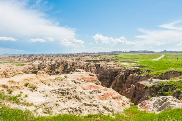 istock Badlands canyons with green grass and road 648455824