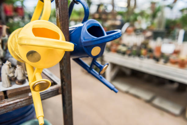 Colorful watering cans hanging in plant nursery