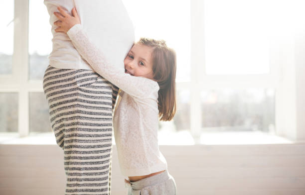 istock Pregnant woman and a child hugging 648470942