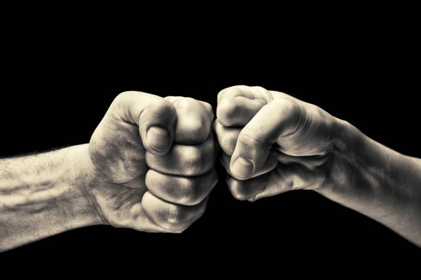scontro in bianco e nero di due pugni - conflict boxing fighting business foto e immagini stock