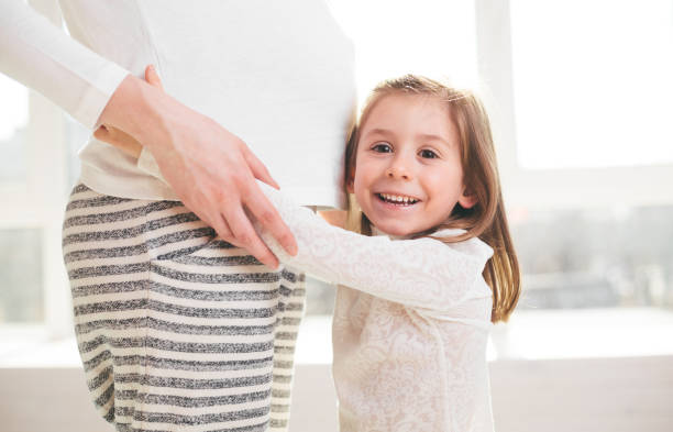 istock Pregnant woman and a child hugging 648470996