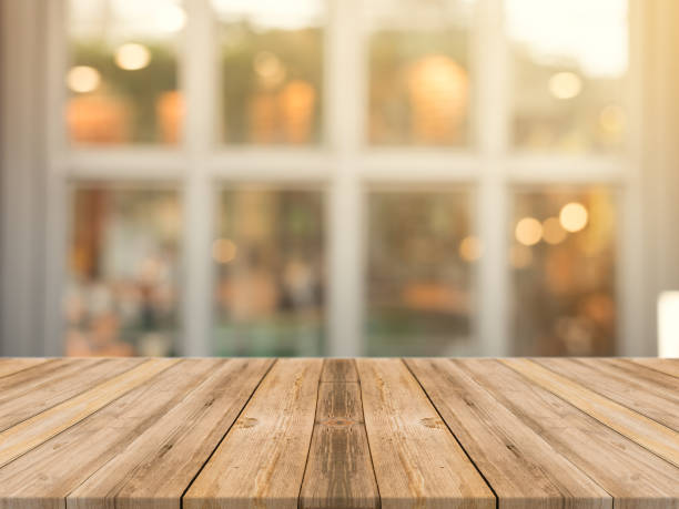 istock Wooden board empty table top on of blurred background. Perspective brown wood table over blur in coffee shop background - can be used mock up for montage products display or design key visual layout. 648489210