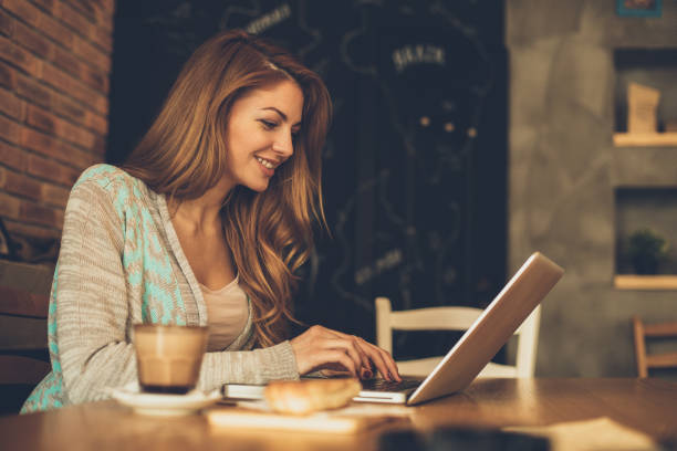 istock Young woman typing on laptop in cafe 648491822