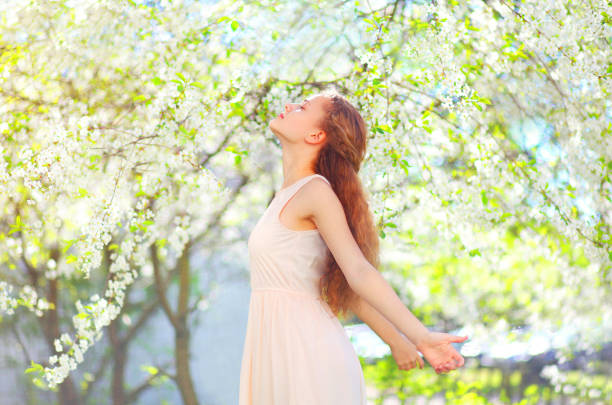 Portrait of beautiful smiling girl near blossom cherry tree brunch  in spring garden