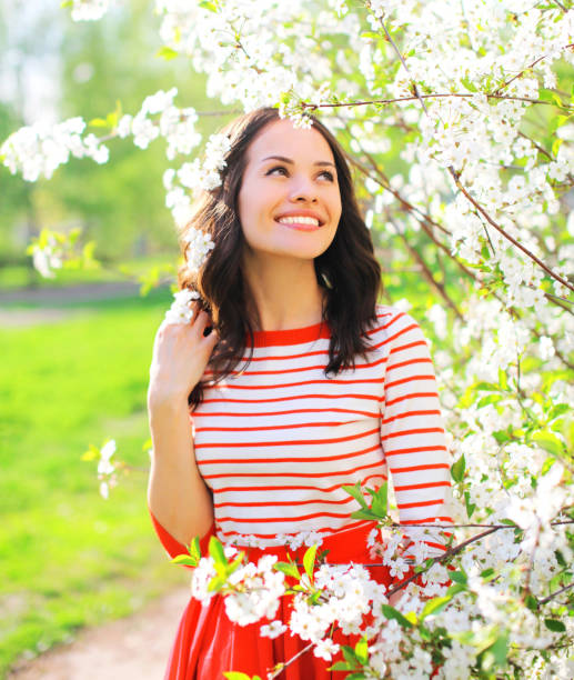 istock Happy smiling young woman over spring flowers background 648498620