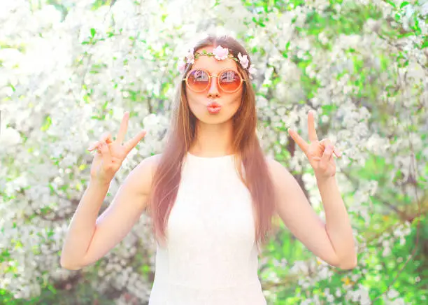Fashion pretty cool hippie girl having fun over flowering garden background