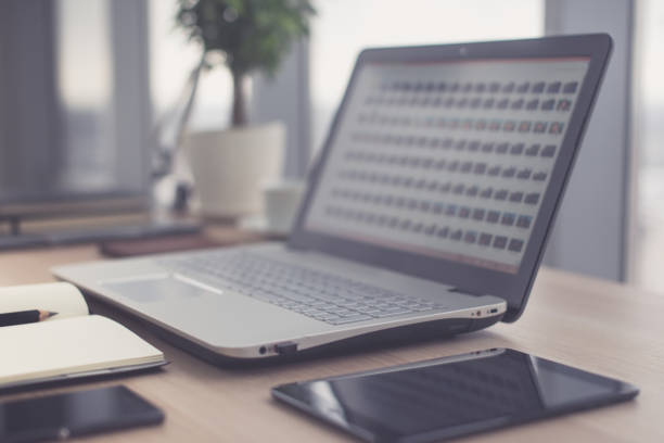 istock Sideview of office desktop with blank laptop and various tools. 648500740