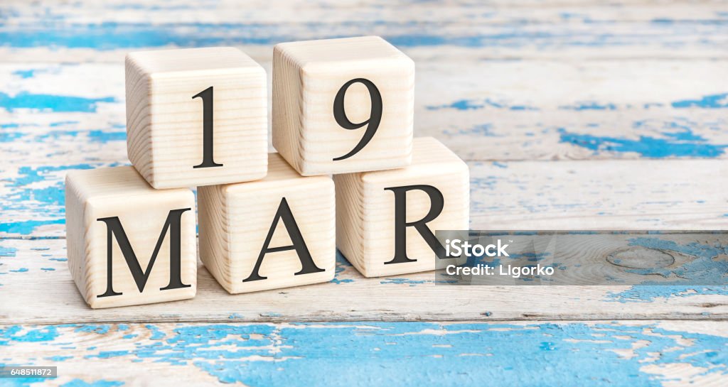 March 19th. Wooden cubes with date of 19 March on old blue wooden background. 19th Century Stock Photo