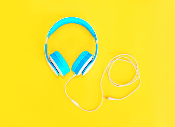 istock Blue headphones lie on colorful yellow background 648521032