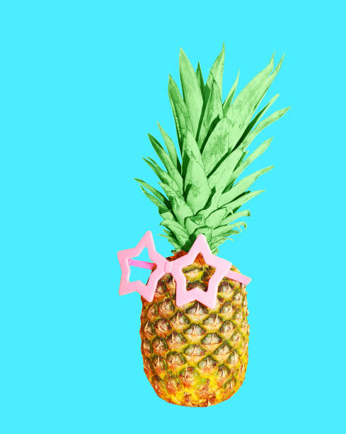 Pineapple with pink sunglasses on blue background, colorful ananas