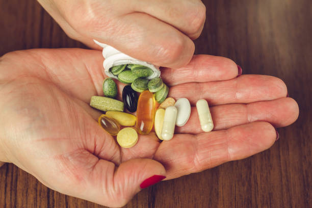 Woman's hands poured the mix of vitamins and nutritional, dietary supplement pills from a bottle, close-up. Woman's hands poured the mix of vitamins and nutritional, dietary supplement pills from a bottle, close-up vitamin a nutrient stock pictures, royalty-free photos & images