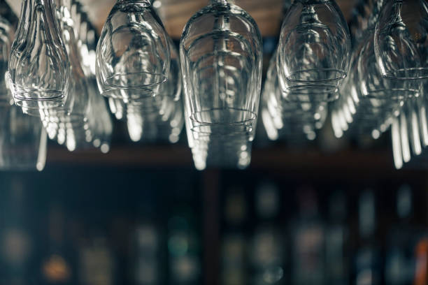 istock On a defocused bar background, view of a group of upside down wine glasses on a rack. 648529888
