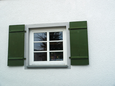 Window with green wooden window shutters