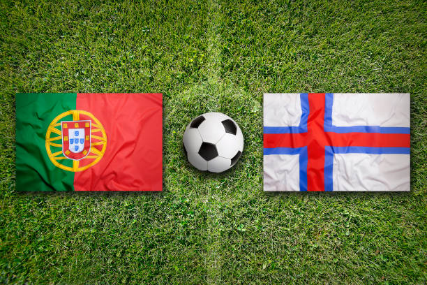 istock Portugal vs. Faeroe Islands flags on soccer field 648561946