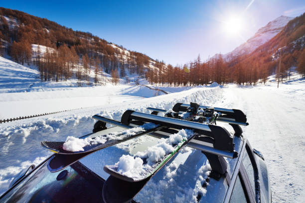 snow-covered skis fastened on car roof rack - snowboard boot imagens e fotografias de stock